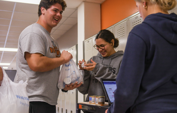 Junior Valentina Maslovaric inspects donated cans Nov. 8 outside of a classroom. Maslovaric collected all kinds of canned goods, but the most common were canned meat or vegetables. “The weirdest can that I saw was definitely a can of coconut meat,” Maslovaric said. “I did not even know people would eat that regularly.” 